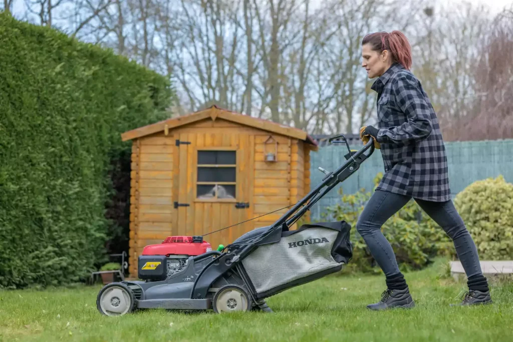 mise en situation jardinier qui tond la pelouse