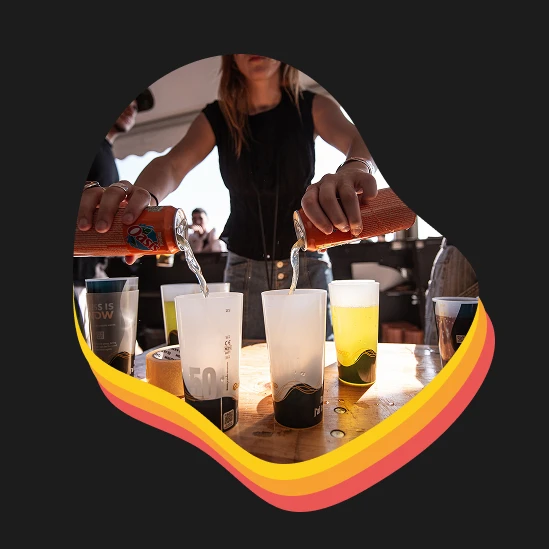 Photo d'une responsable de bar en train de servir des canettes dans des éco-cups