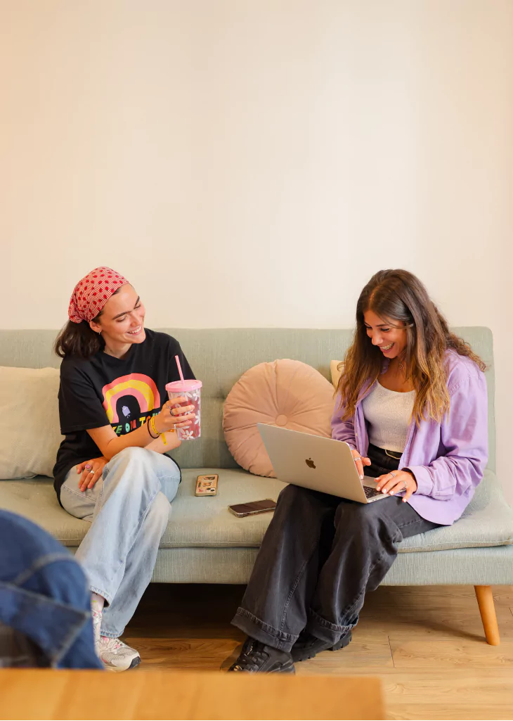Photo de Charlotte et Maram en train de travailler sur un canapé