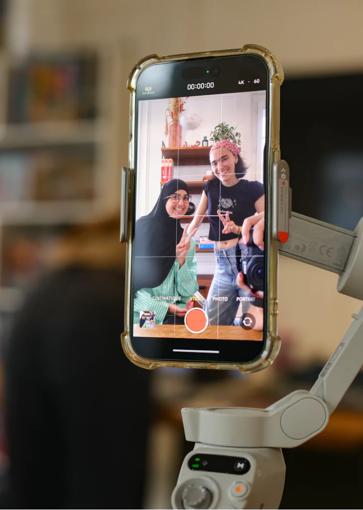 Photo de Assia et Charlotte en train de tourner une vidéo sur un téléphone