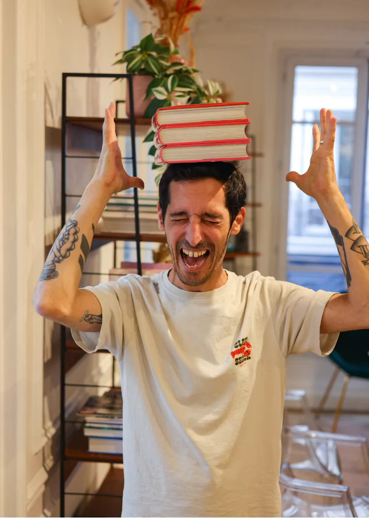 Photo de Guillaume qui fait tenir des livres en équilibre sur sa tête