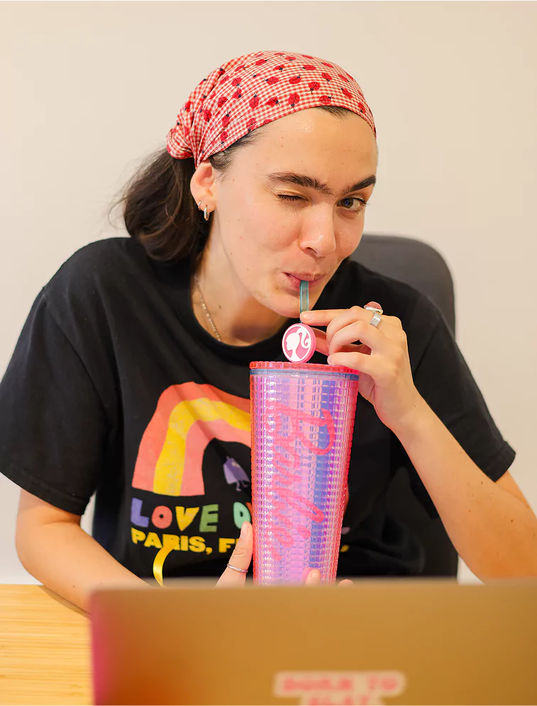 Photo de Charlotte à son poste de travail avec un thermos Barbie