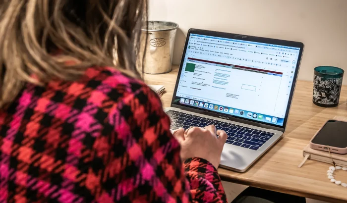 Femme travaillant sur un ordinateur portable avec un tableau de suivi SEO et marketing digital