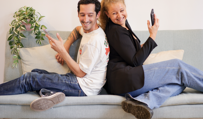 Deux personnes utilisant leur téléphone dans une stratégie social media B2B.